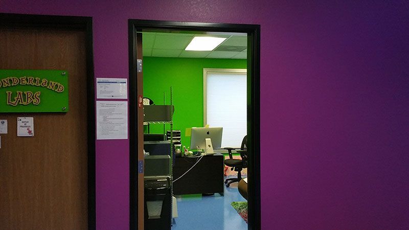 A doorway leading to a room with purple walls and green walls