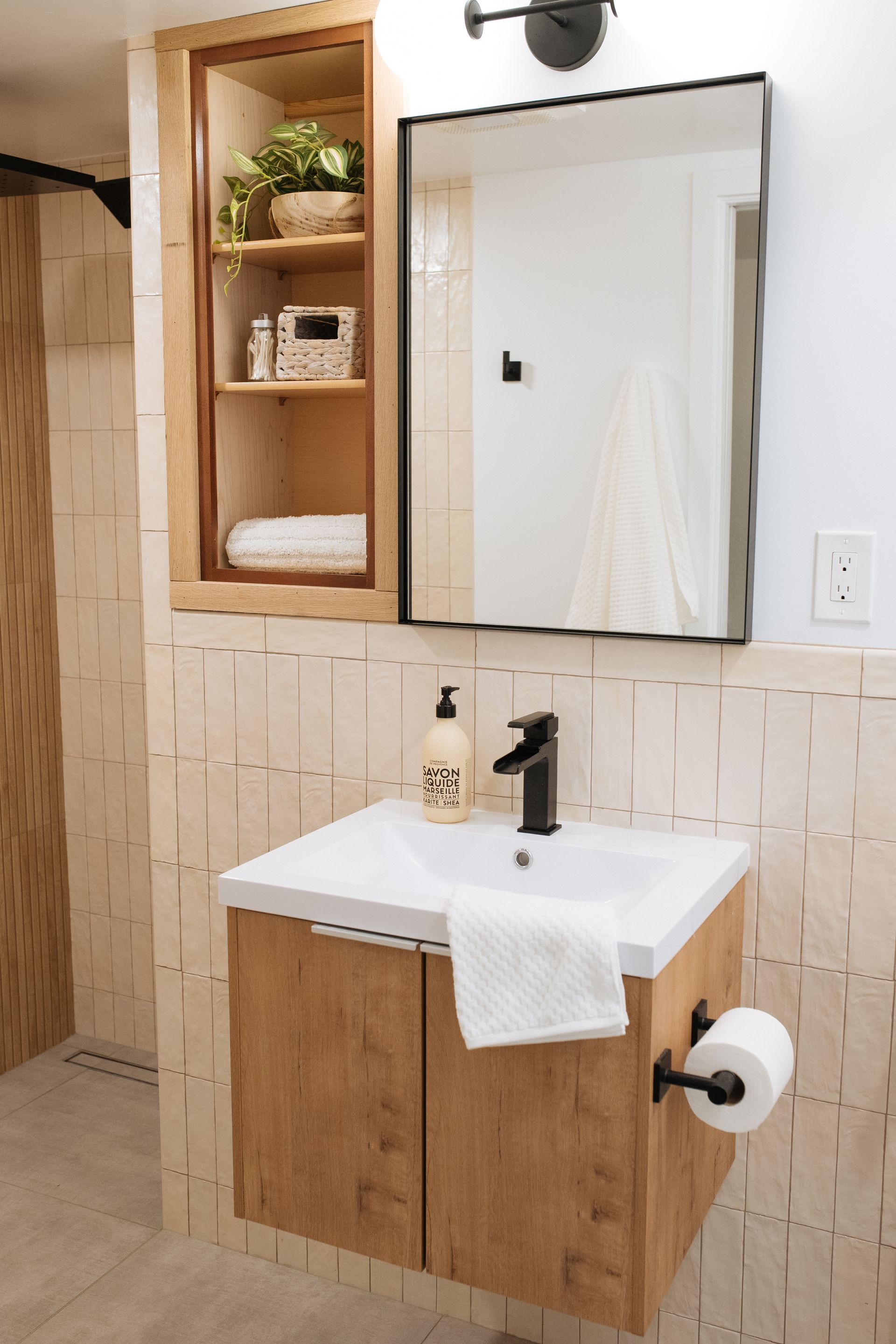 A bathroom with a sink , mirror and cabinet from a Bathroom remodel in San Diego CA by Team  Renovate