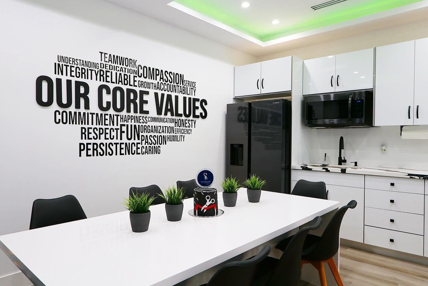 A kitchen with a table and chairs and a wall that says `` our core values ''.