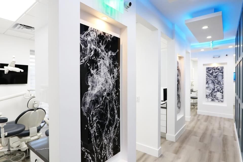 A hallway in a dental office with a painting on the wall.