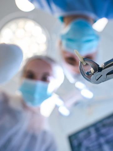 A group of dentists are operating on a patient in an operating room.