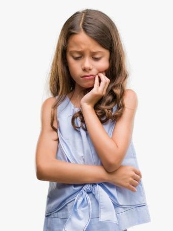 A young girl is making a sad face with her hands on her face.