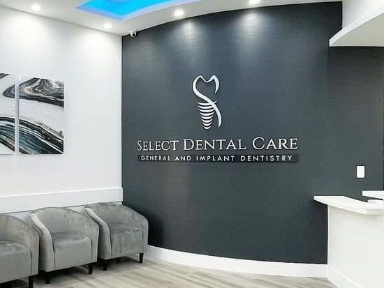 A waiting room with chairs and a sign for select dental care.