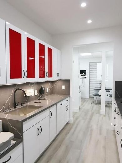 A kitchen with red and white cabinets and a sink