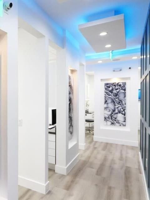 A hallway in a dental office with blue lights on the ceiling