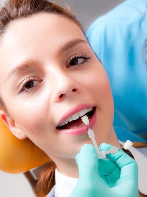 A woman is getting her teeth examined by a dentist.