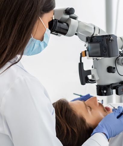 Dentist using a microscope on a patient in a dental office.