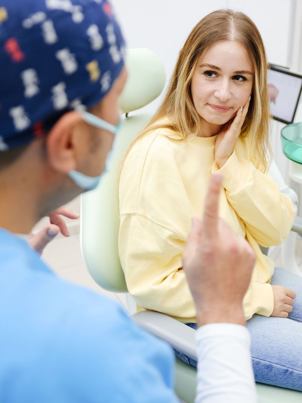 A woman is sitting in a dental chair with a toothache.