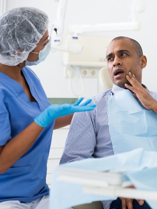 A woman is sitting in a dental chair with a toothache.