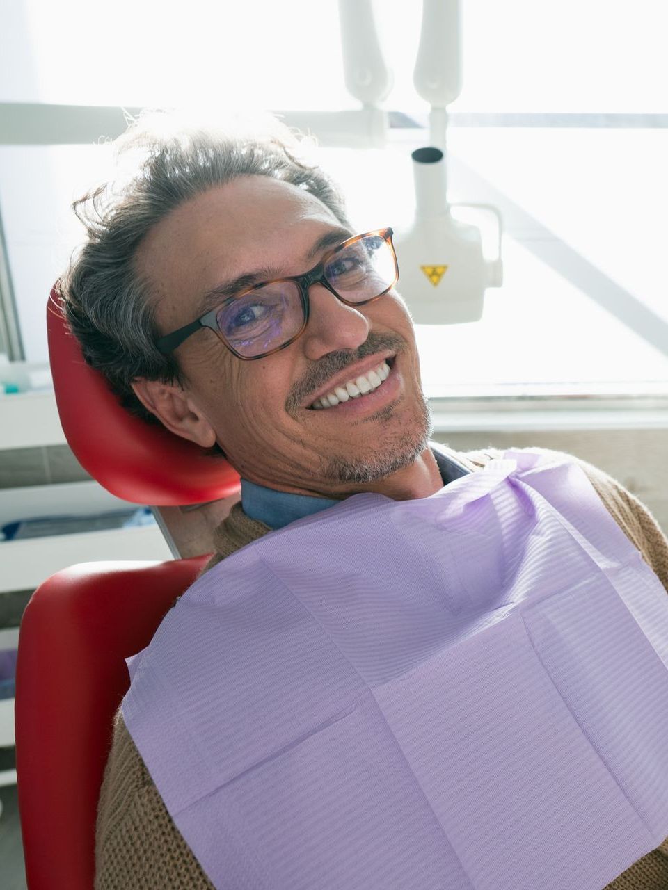 A woman is sitting in a dental chair with a toothache.