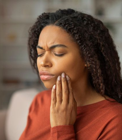 A woman is sitting in a dental chair with a toothache.