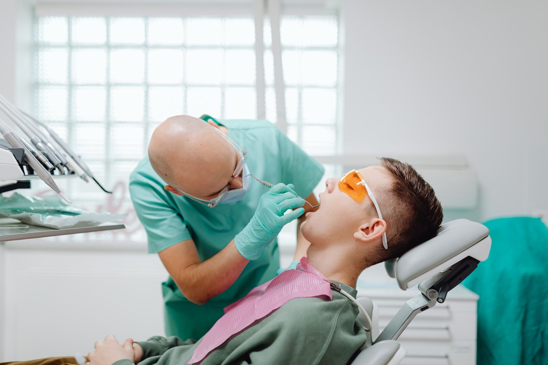 dentist cleaning young patient's mouth