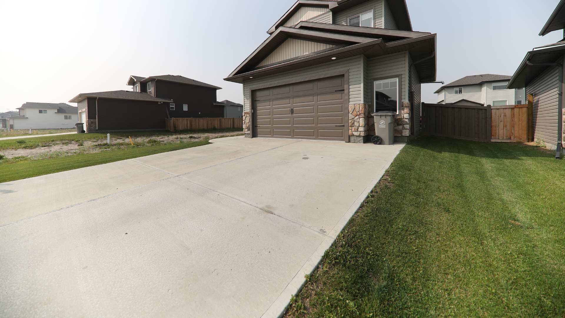 A house with a garage and a driveway in front of it.