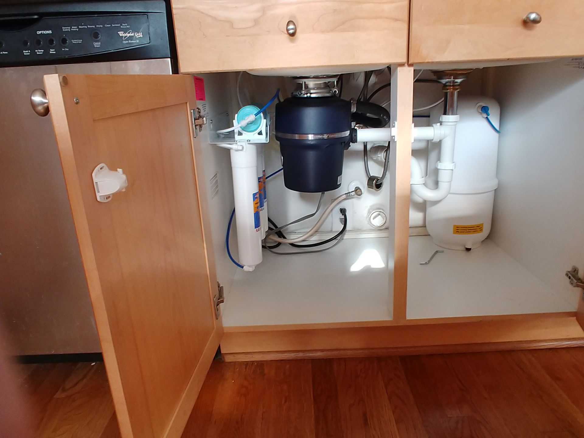 Under-sink Platinum Series Omnipure reverse osmosis system with quick-change filters installed professionally with clean, organized tubing. Tight fit, it cannot touch the garbage disposal. 