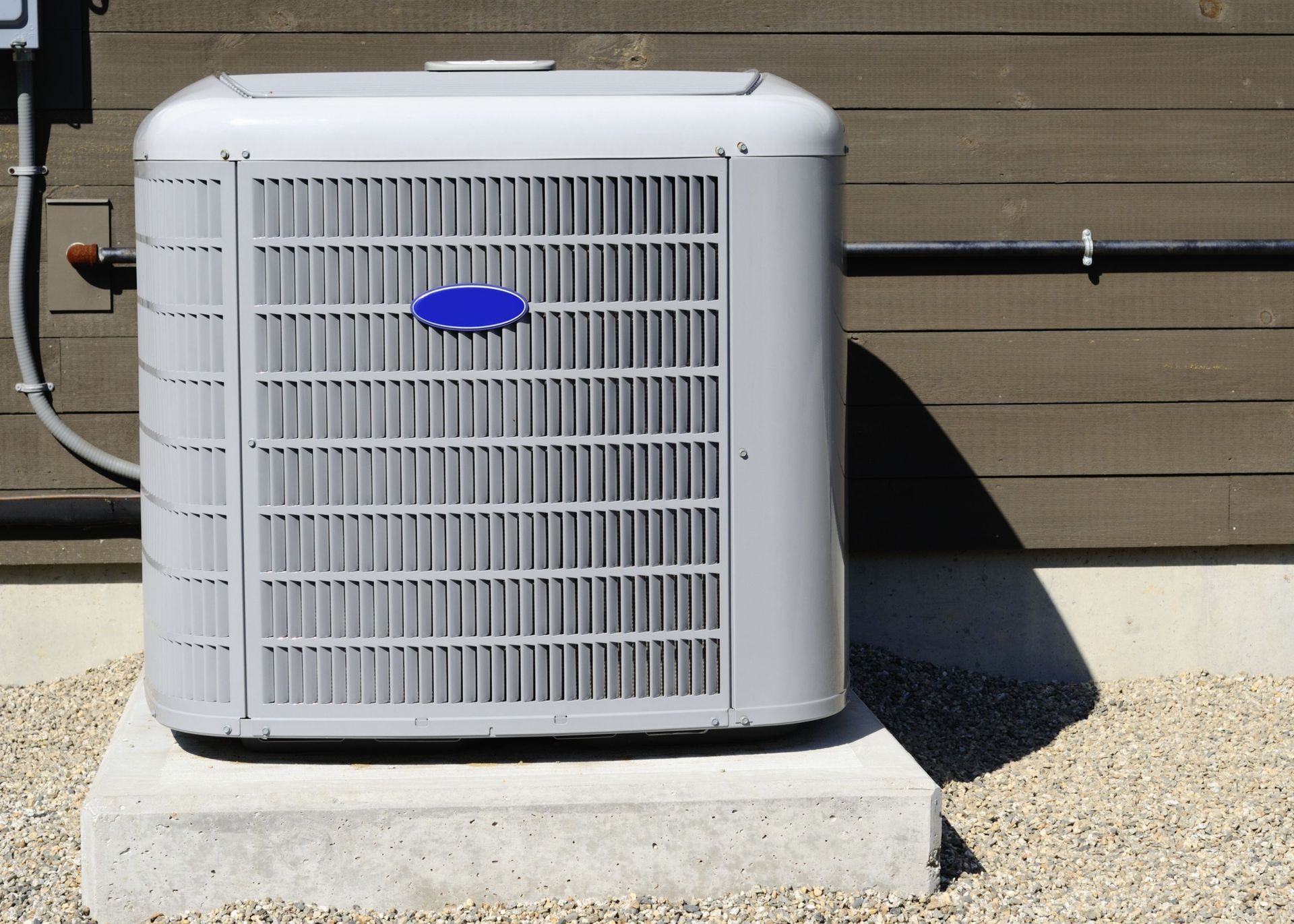 A carrier air conditioner is sitting outside of a building