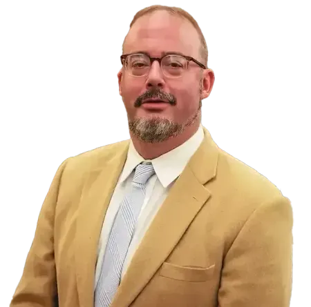 Man in tan blazer and glasses, looking at the camera. He has a goatee and a striped blue tie.