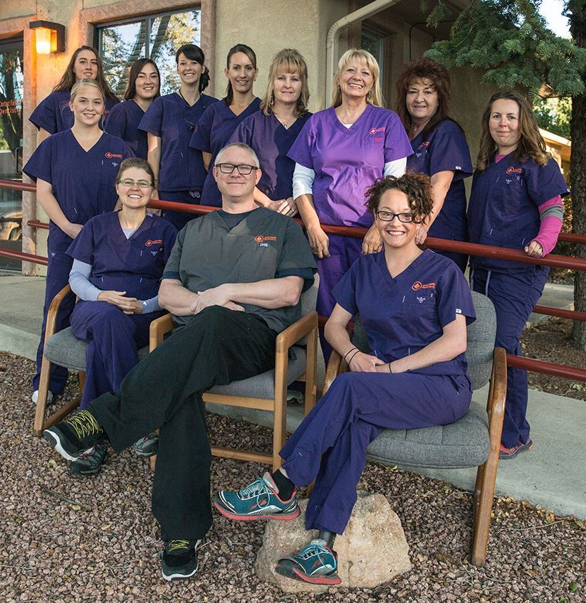 A group of nurses in purple scrubs pose for a picture