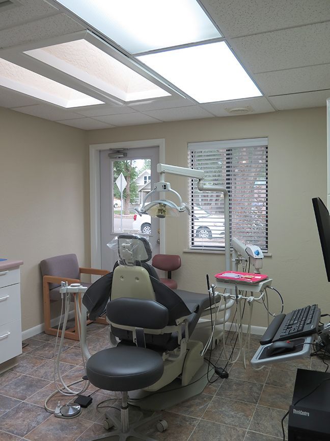 A dental office with a dental chair and a computer