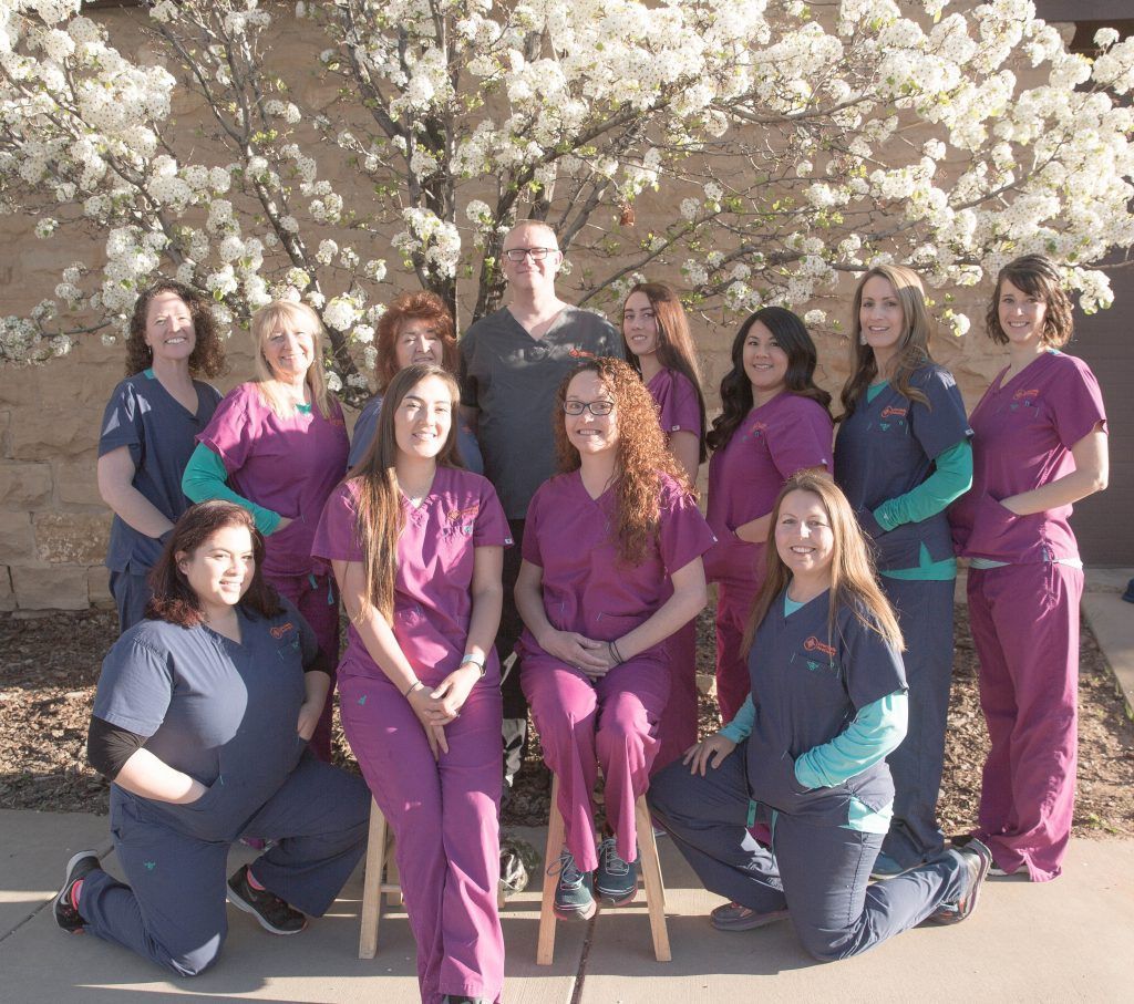 A group of nurses posing for a picture in front of a flowering tree