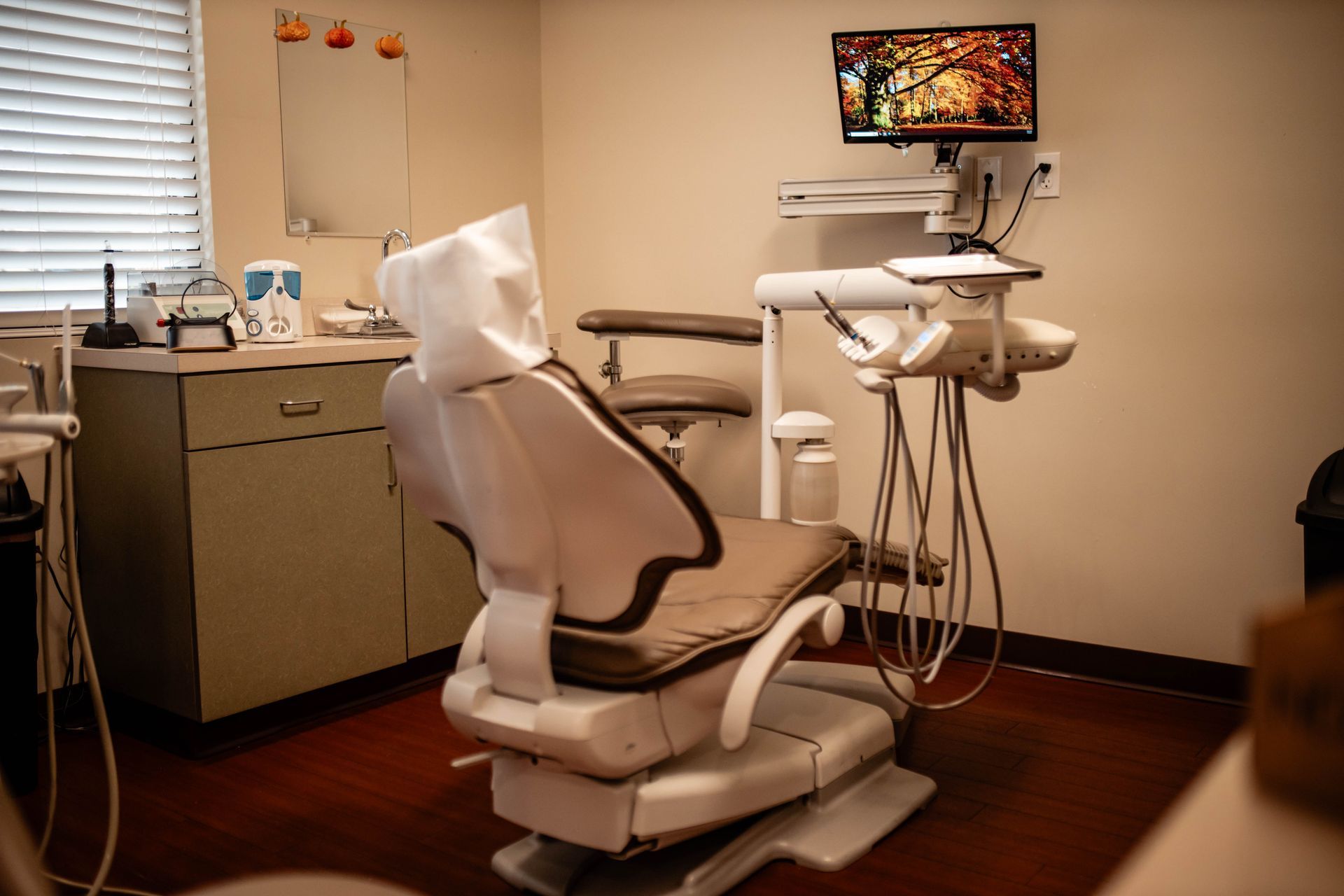 A dental office with a dental chair and a computer monitor.