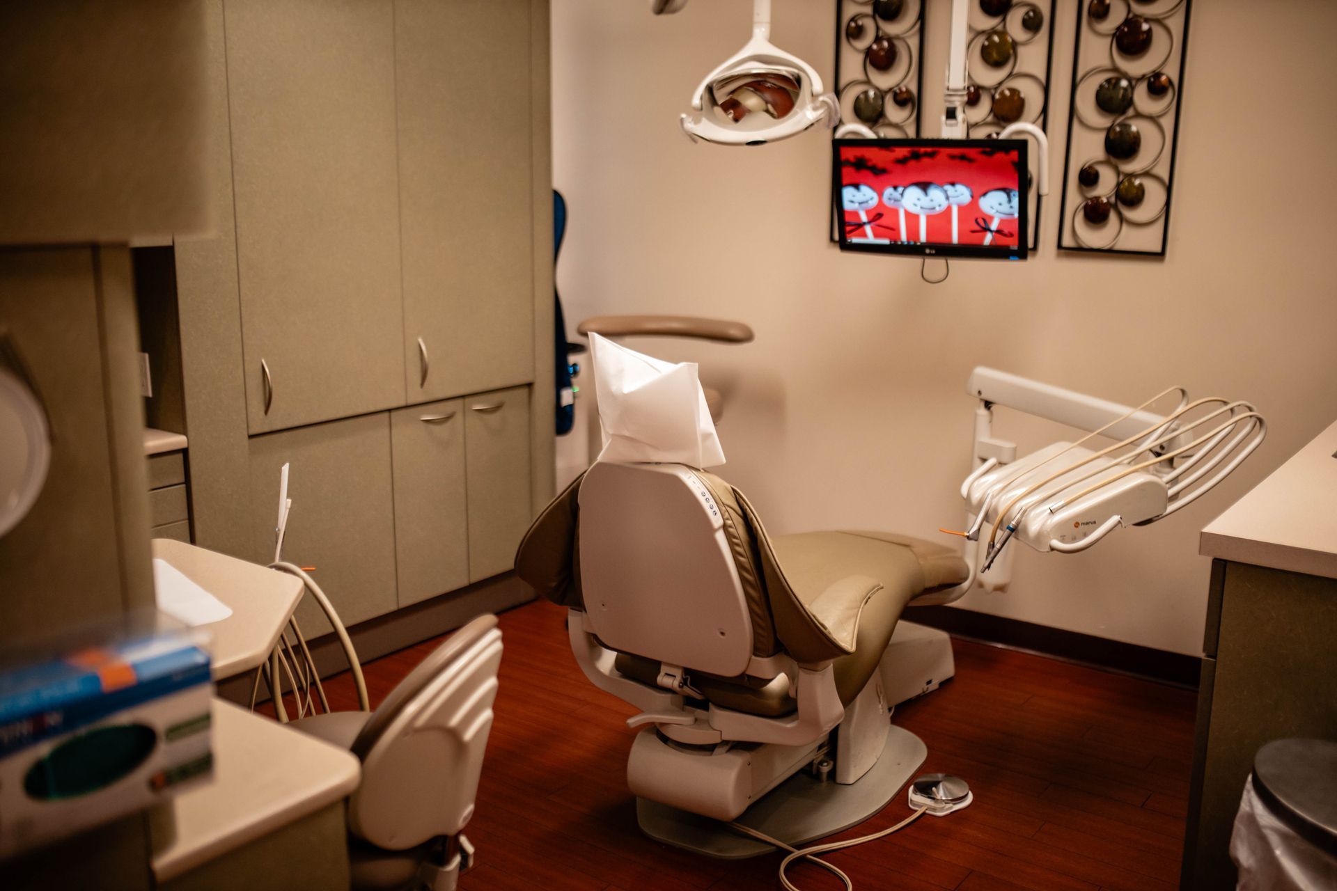 A dental office with a dental chair and a television on the wall.