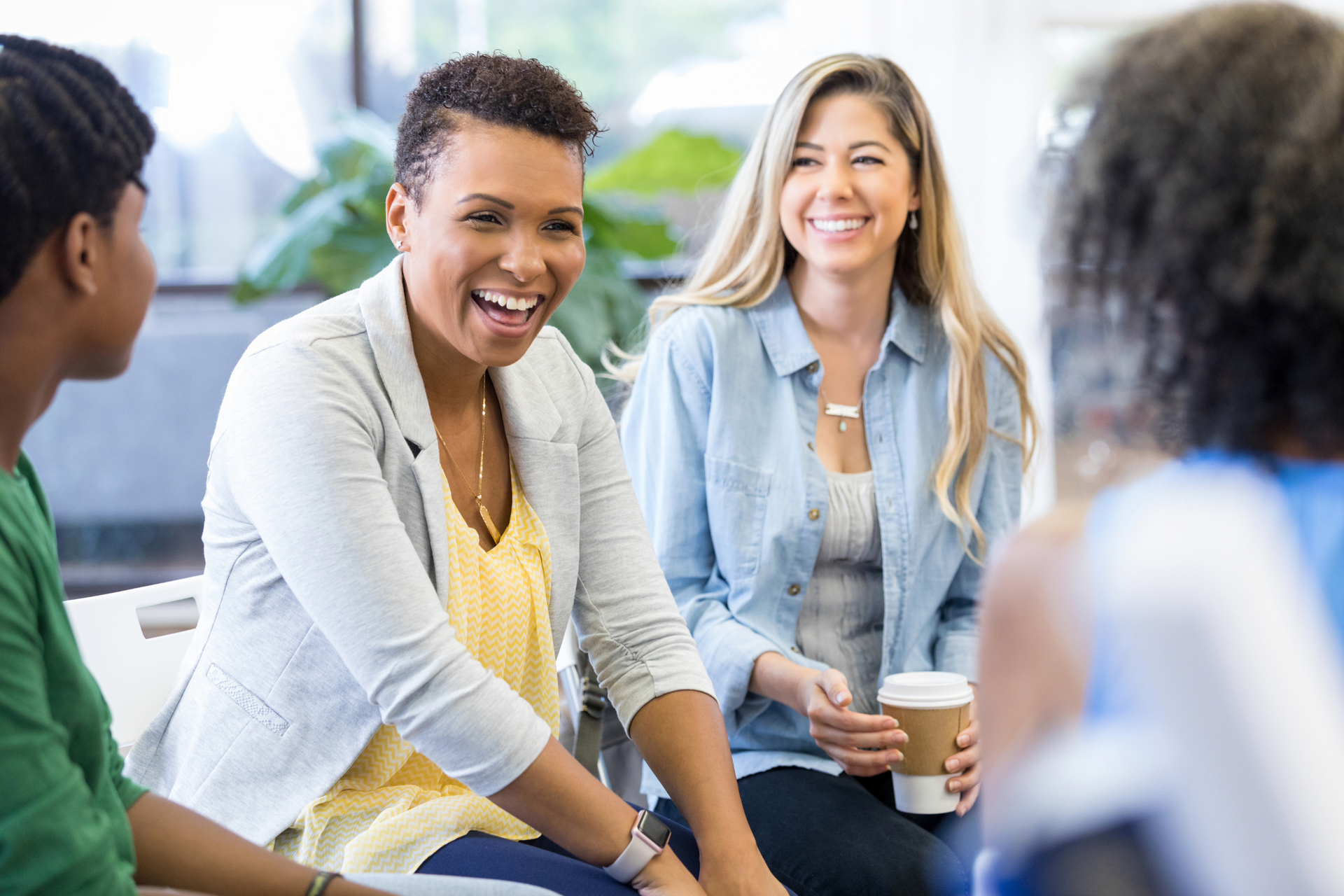 A group of people are sitting in a circle talking to each other.