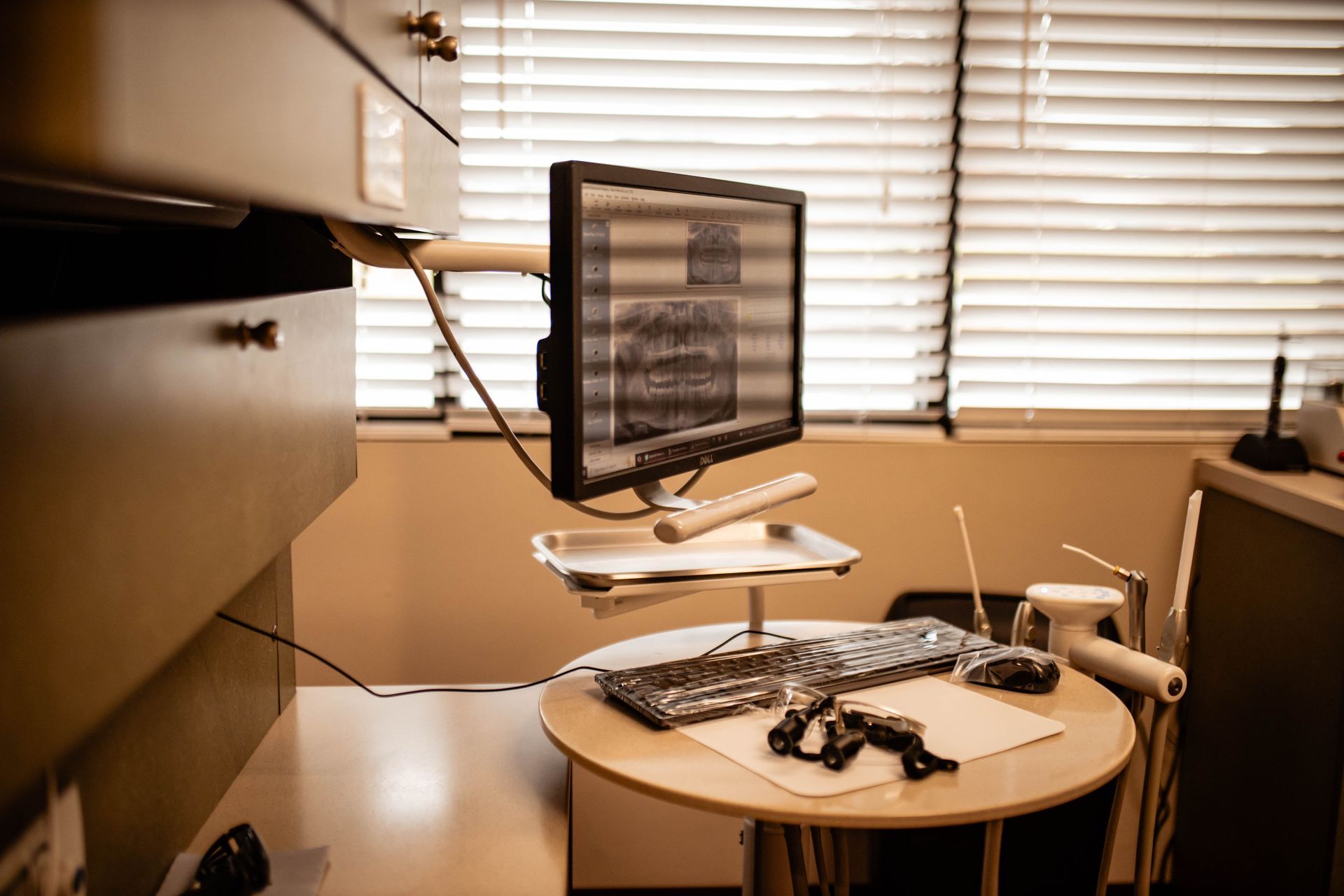 A computer monitor is sitting on top of a table in a dental office.