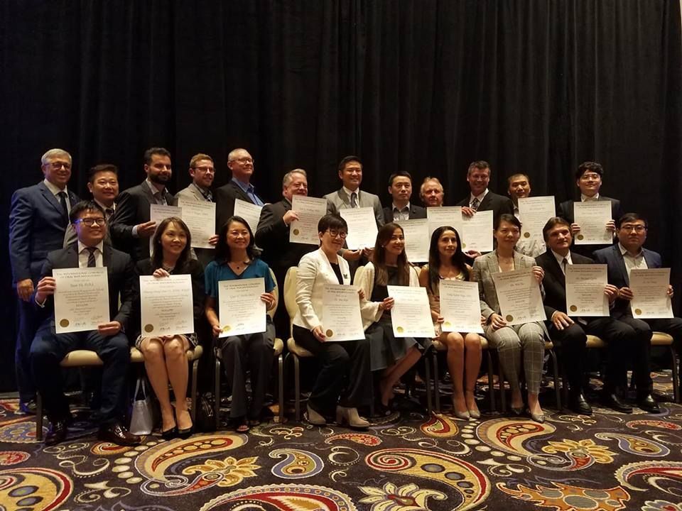 A group of people are posing for a picture while holding certificates.