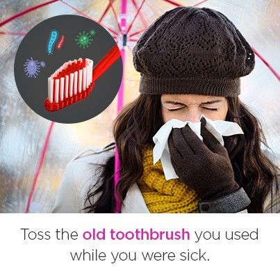 A woman is blowing her nose while holding a toothbrush.