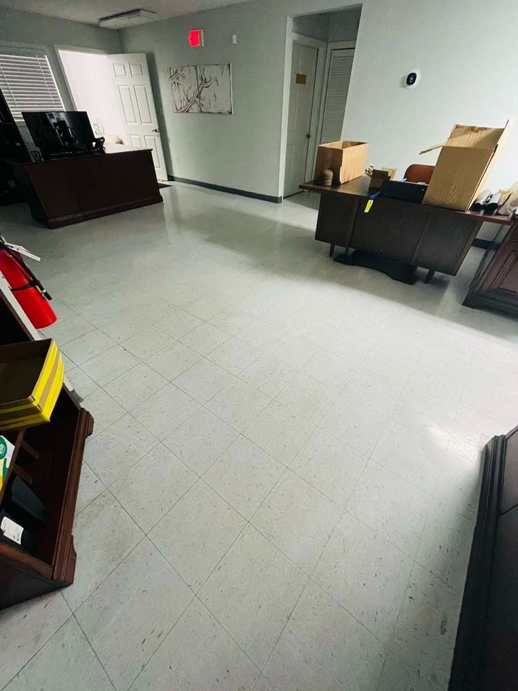 Office space with desks, boxes, and white tile floor.