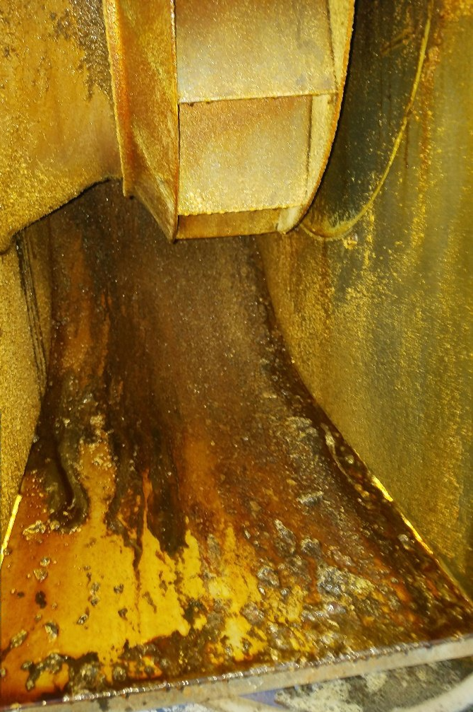 a close up of a rusty metal surface with a fan in the background .