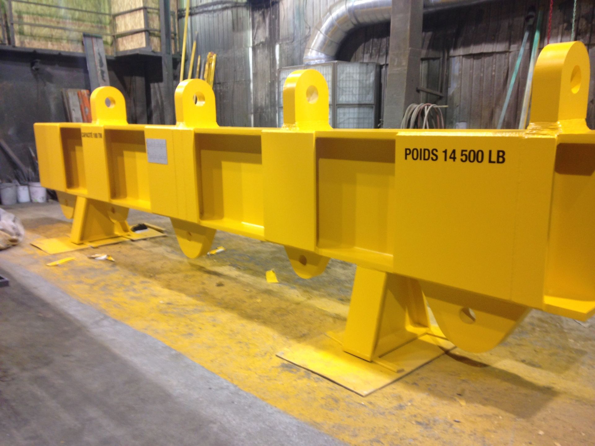 Poutre de levage industrielle jaune avec plusieurs points de levage et une capacité nominale de 14 500 lb.
