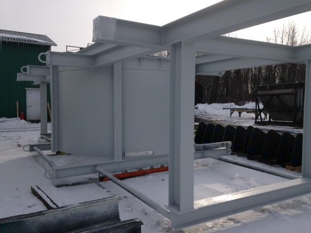 Structure industrielle en métal gris dans un décor extérieur enneigé.