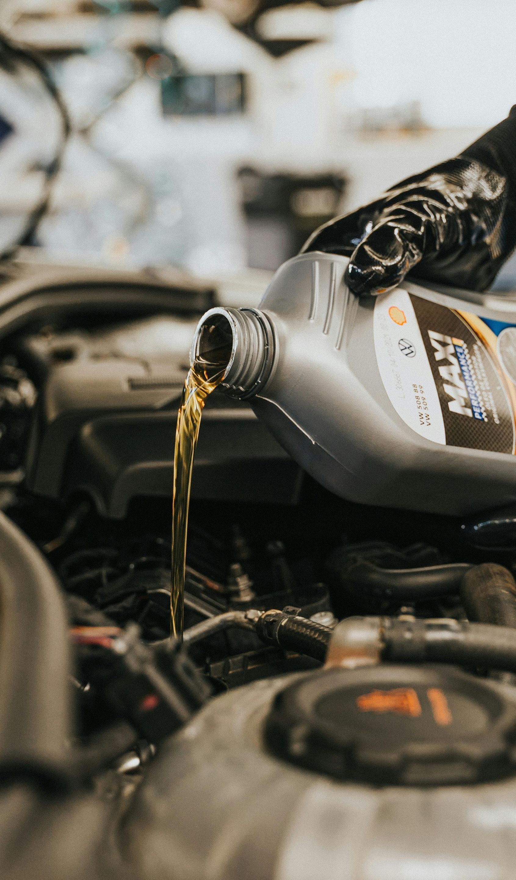A person is pouring oil into a car engine.