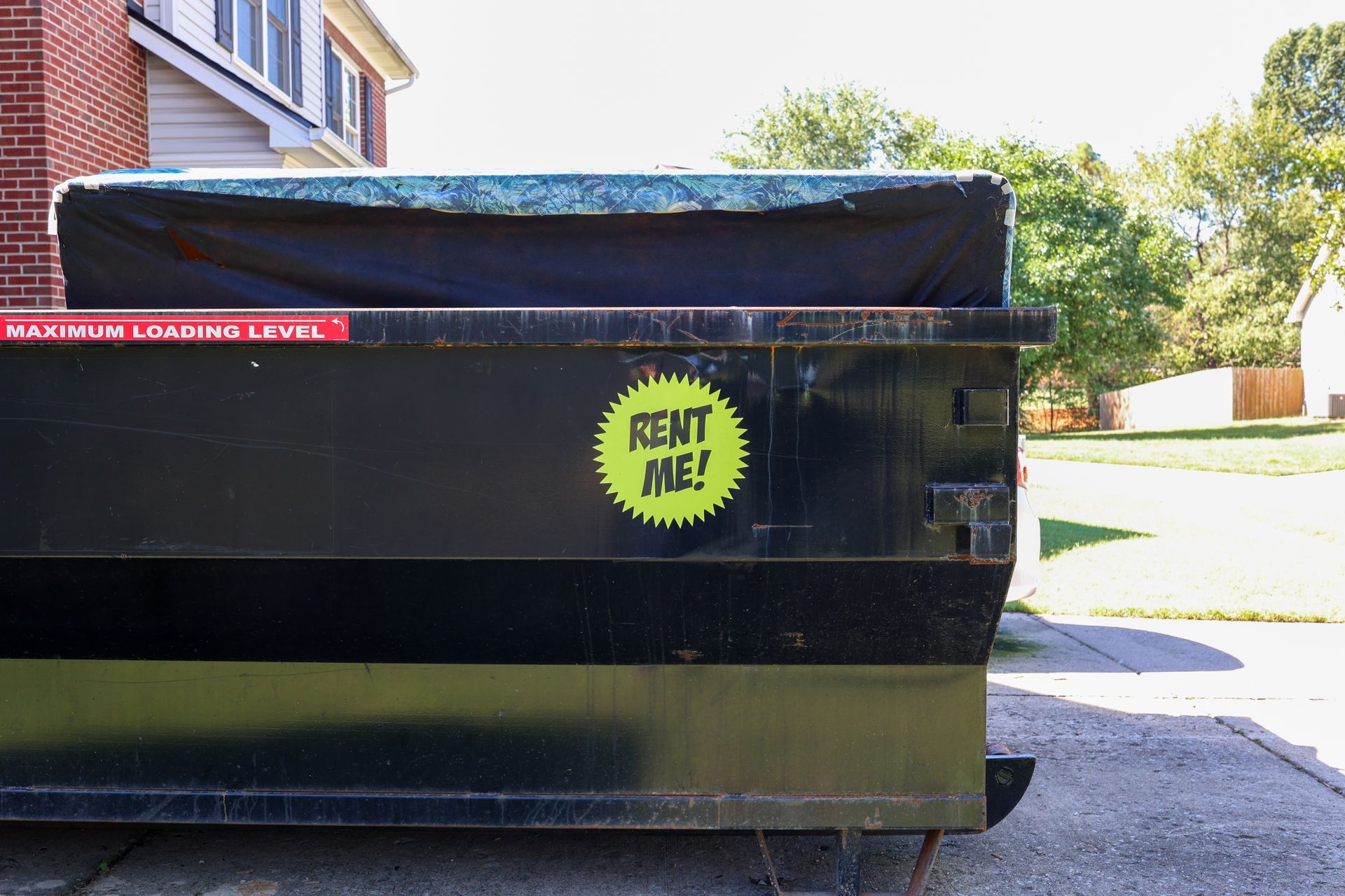 Rented dumpster neatly placed in a residential driveway.