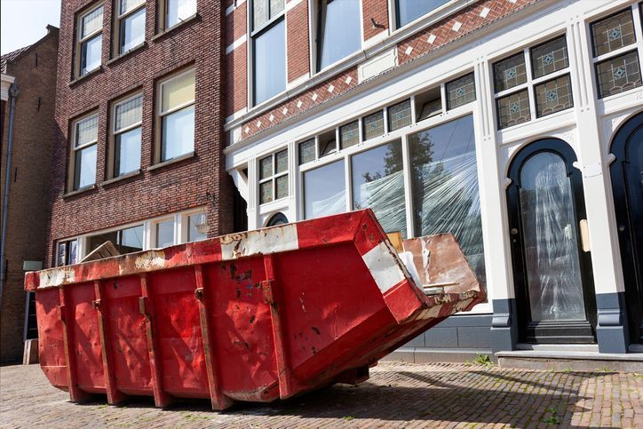 Red skip for dumping renovation waste in a street.