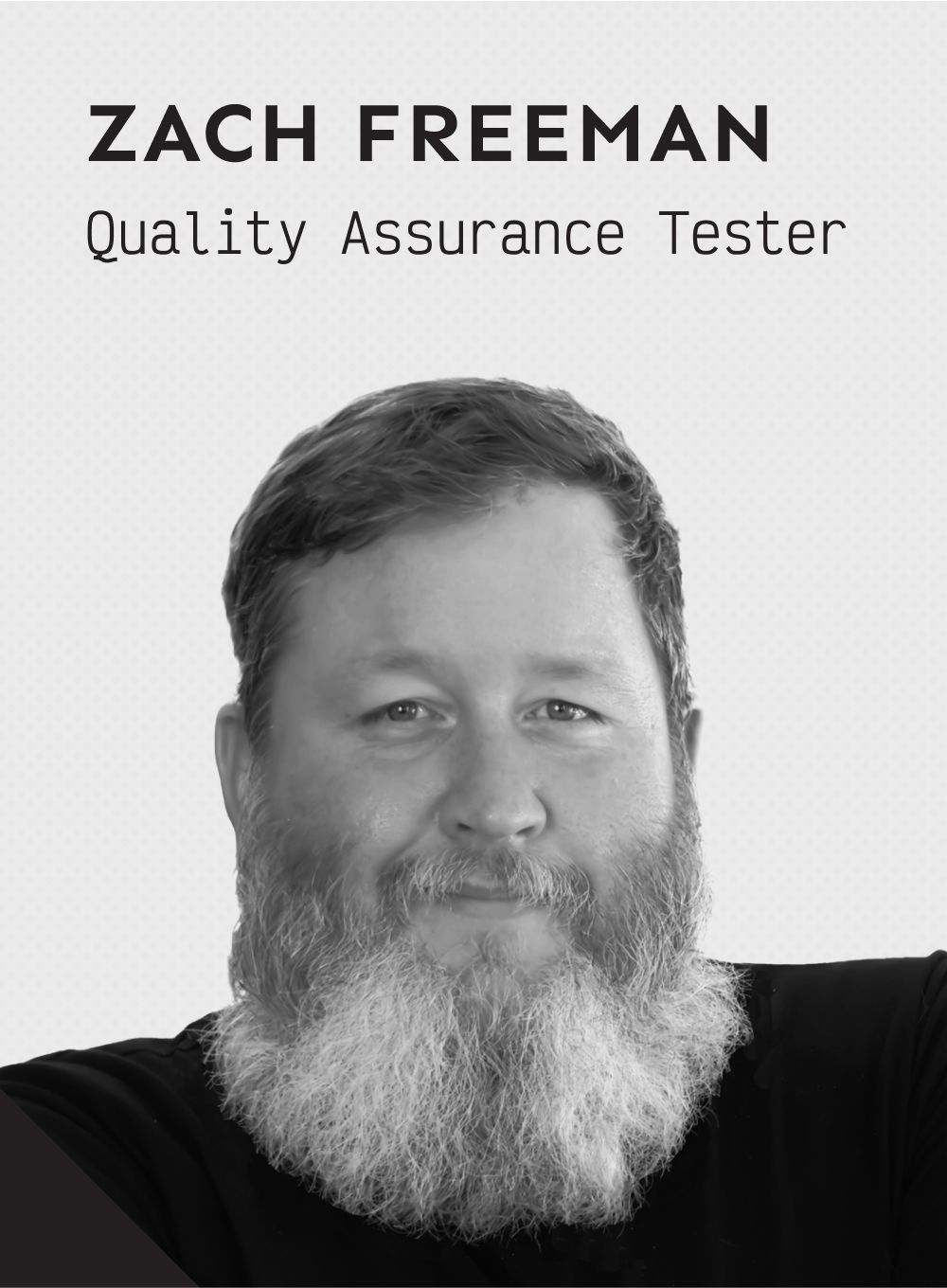 A black and white photo of a smiling man named Zach Freeman, Quality Assurance Tester.