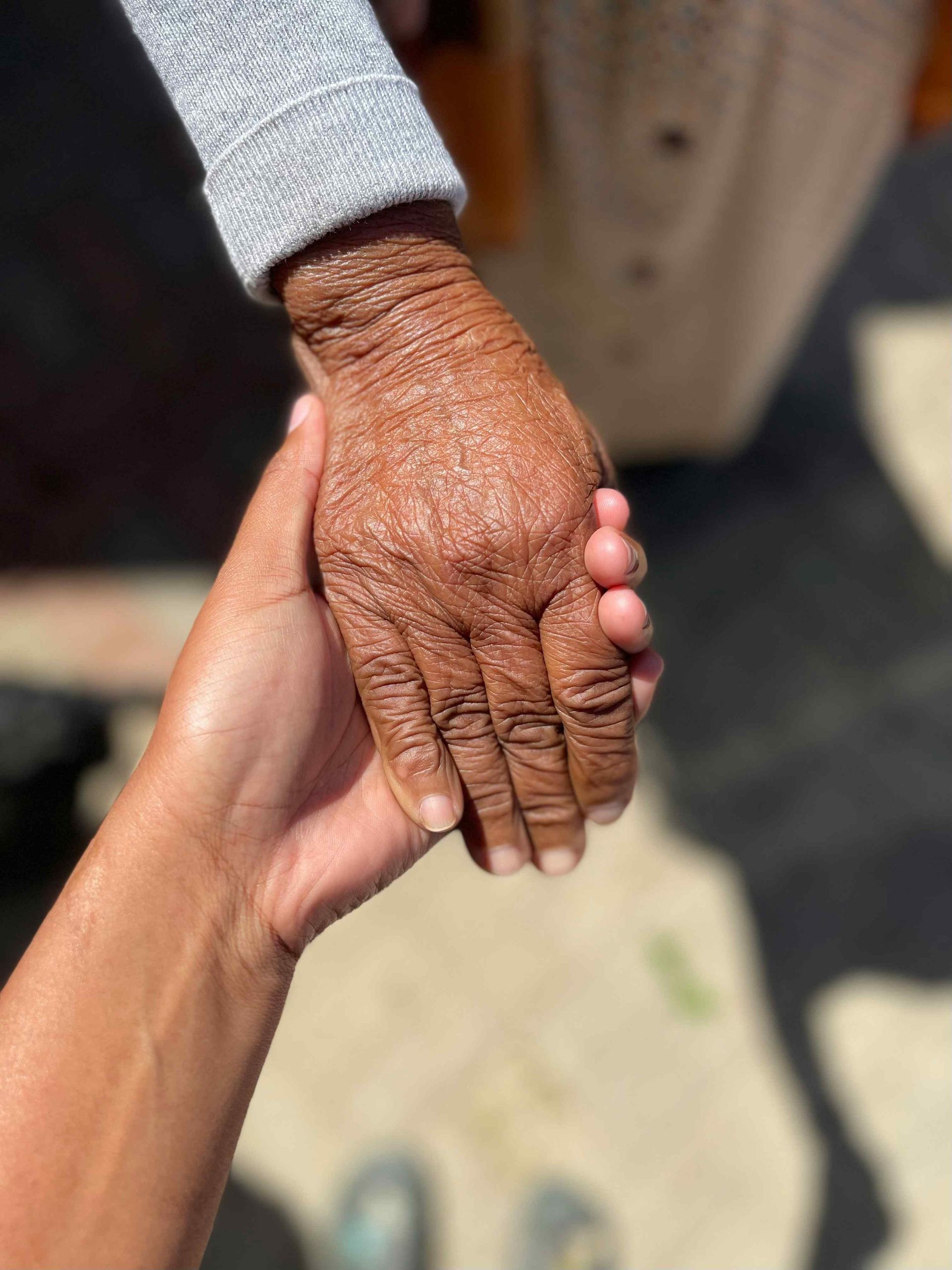 A close up of a person holding an older person 's hand