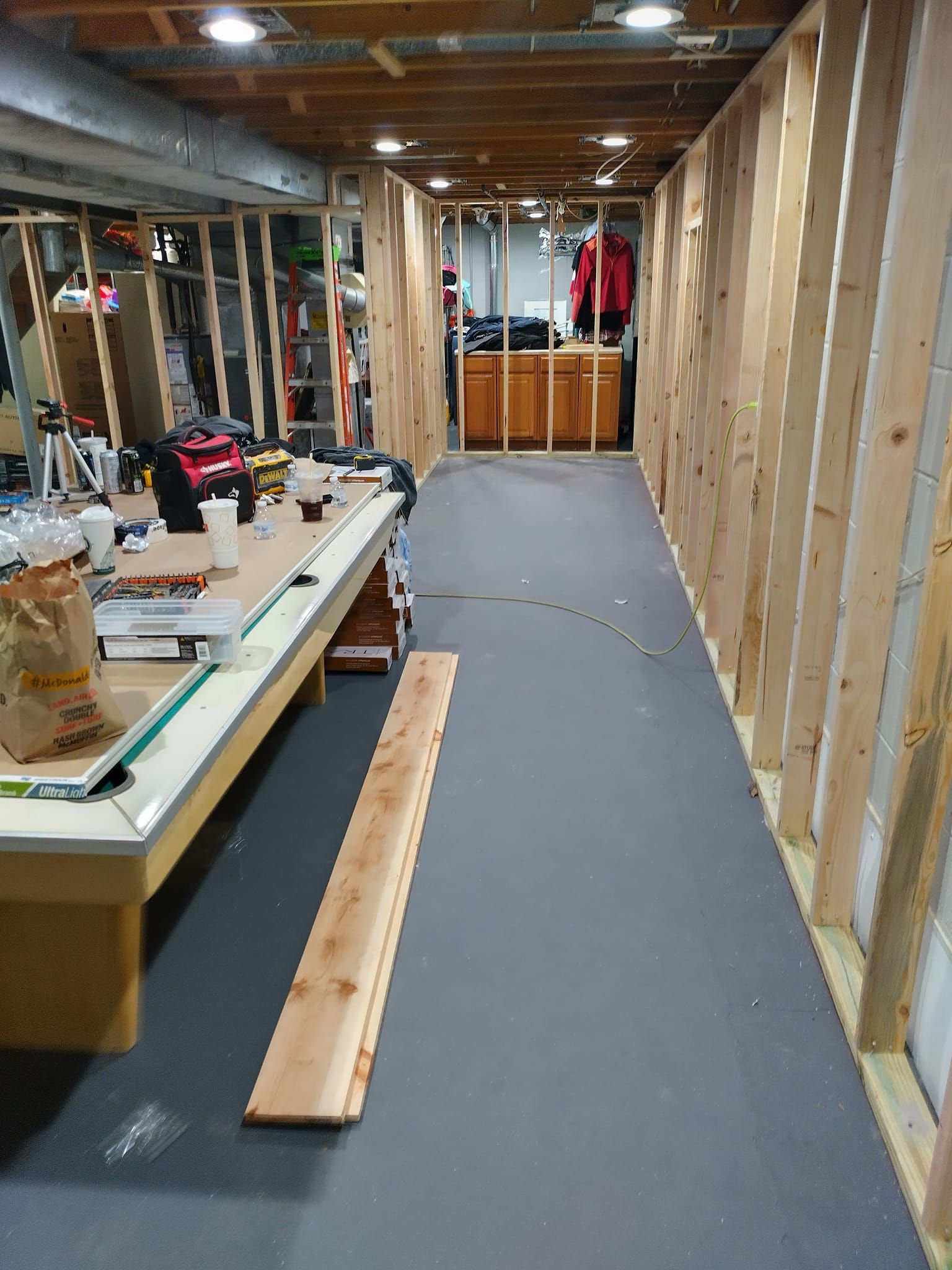 A long hallway with a wooden table in the middle of it.