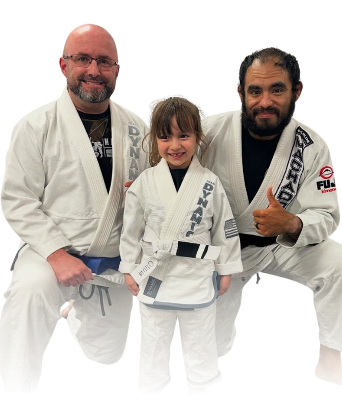 Man pointing, smiling, wearing black hoodie; arm tattoo visible.