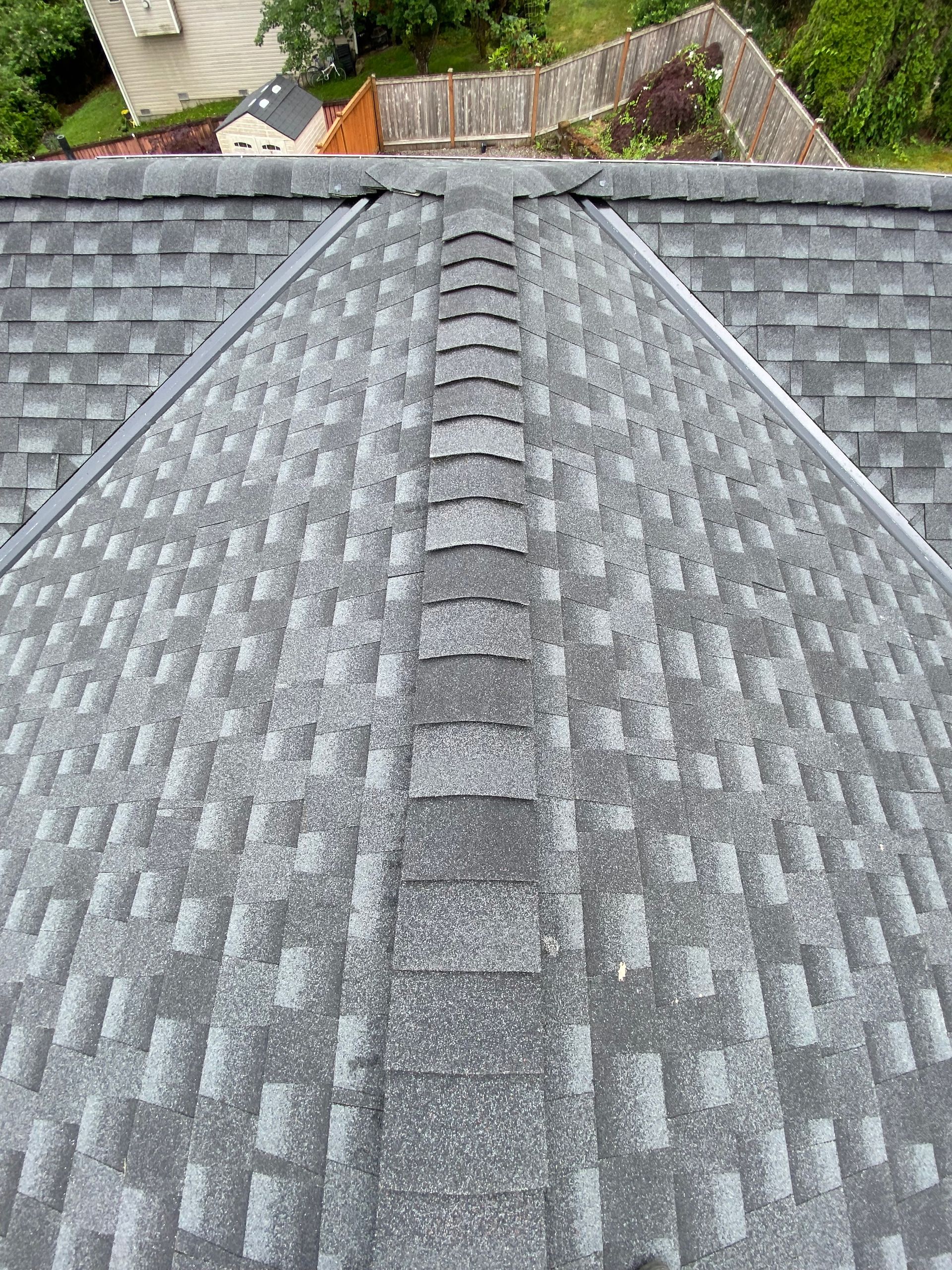 Gray asphalt shingle roof, with a central ridge and visible gutters and ridge cap.