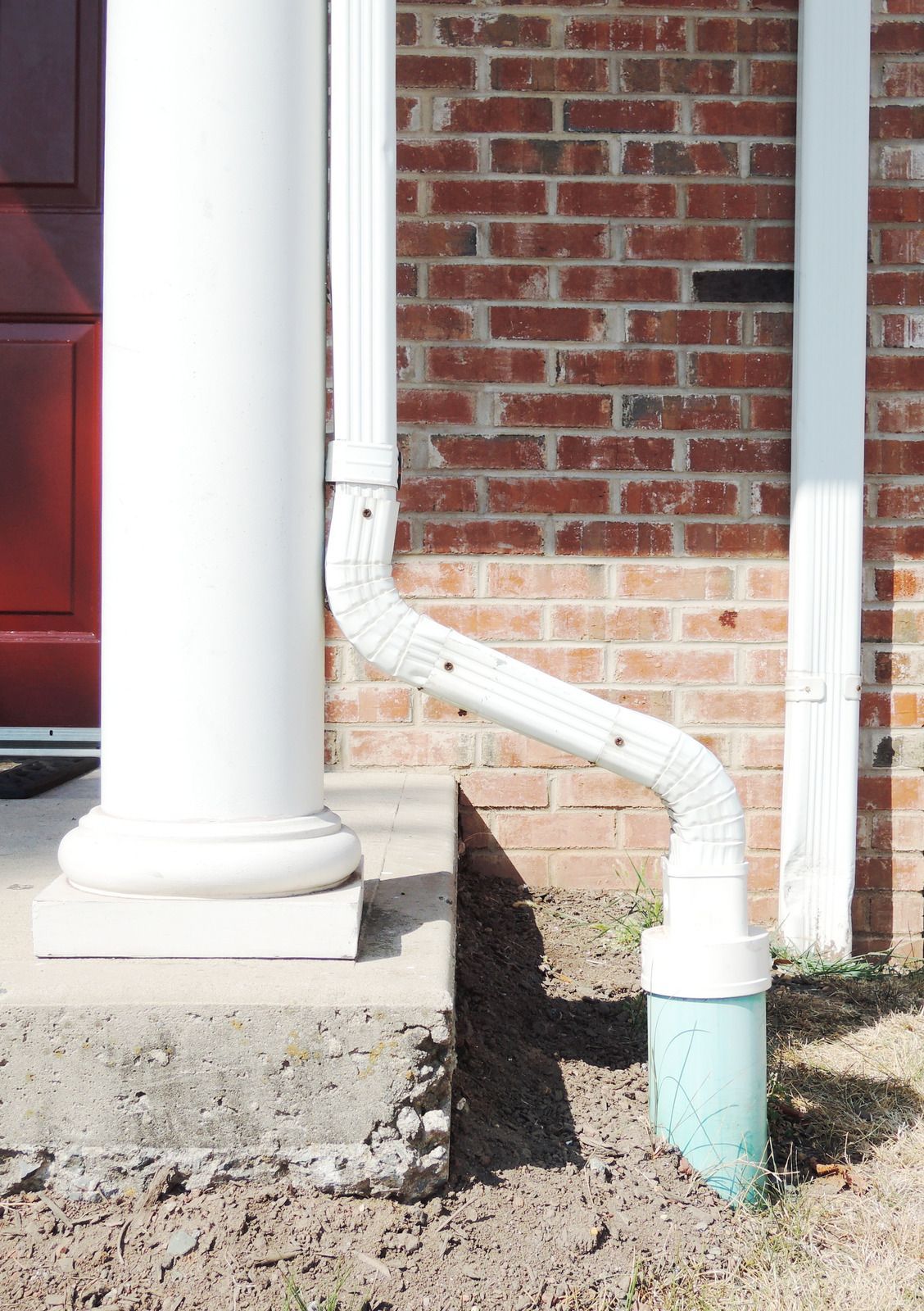 Woman in green shirt smiles while pushing a cleaning cart in a modern building.