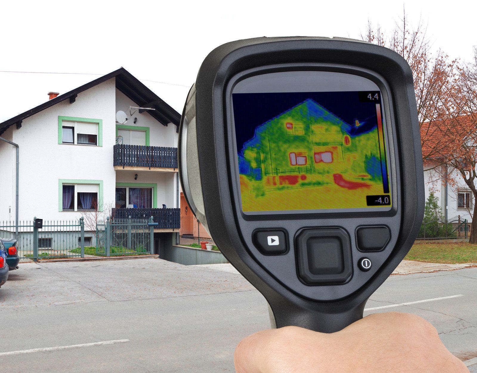 Woman in green uniform smiles, holding papers, amidst indoor plants.