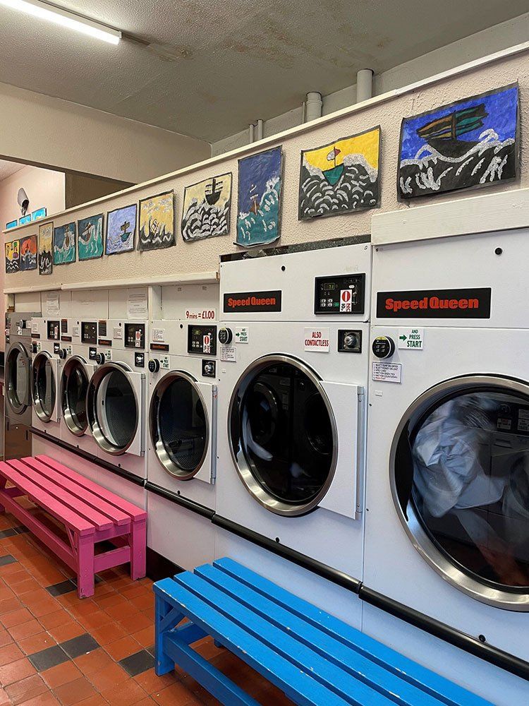 Woman hand put quarter coin on laundry machine