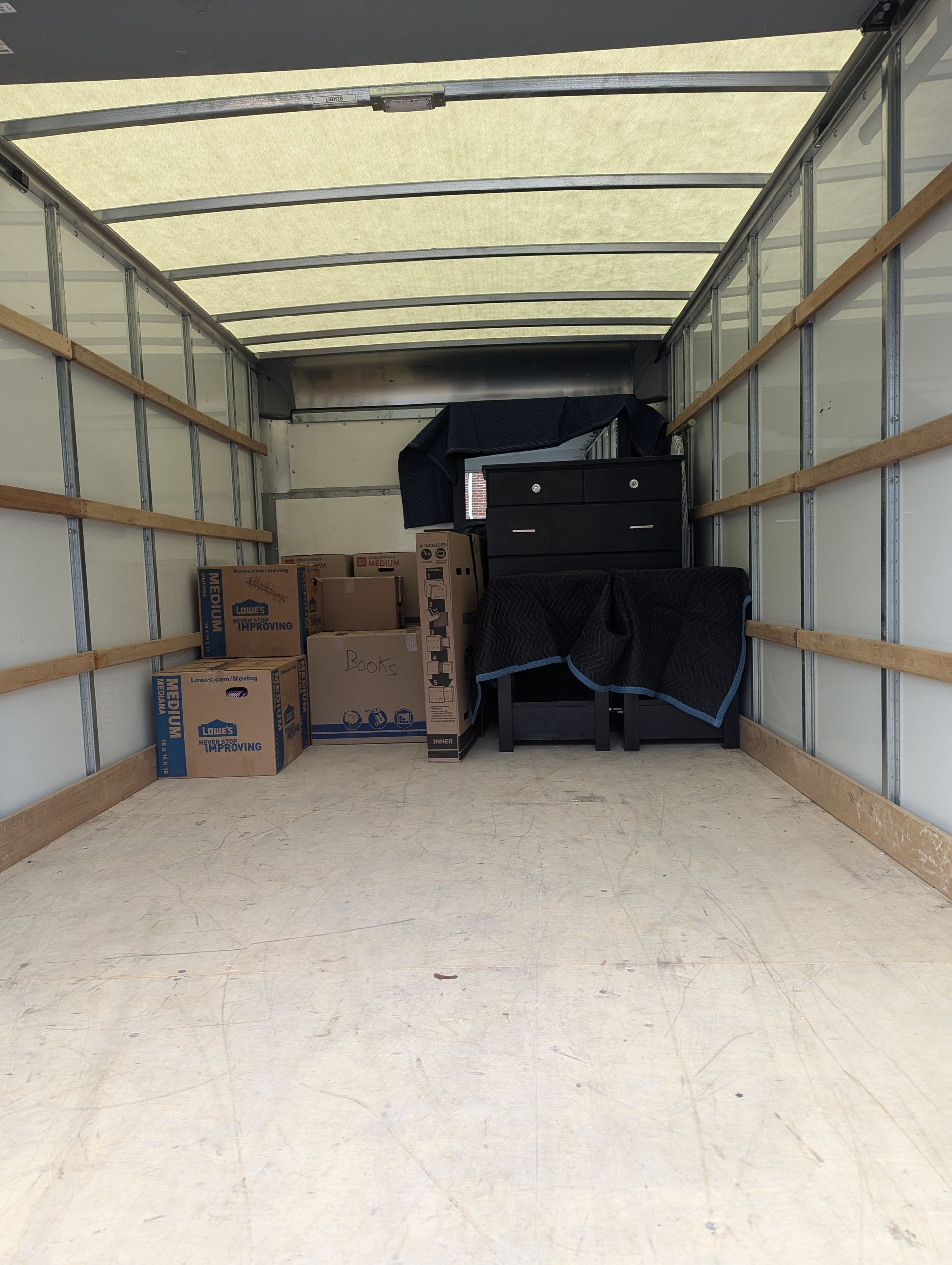 Inside of a moving truck with packed boxes and furniture.