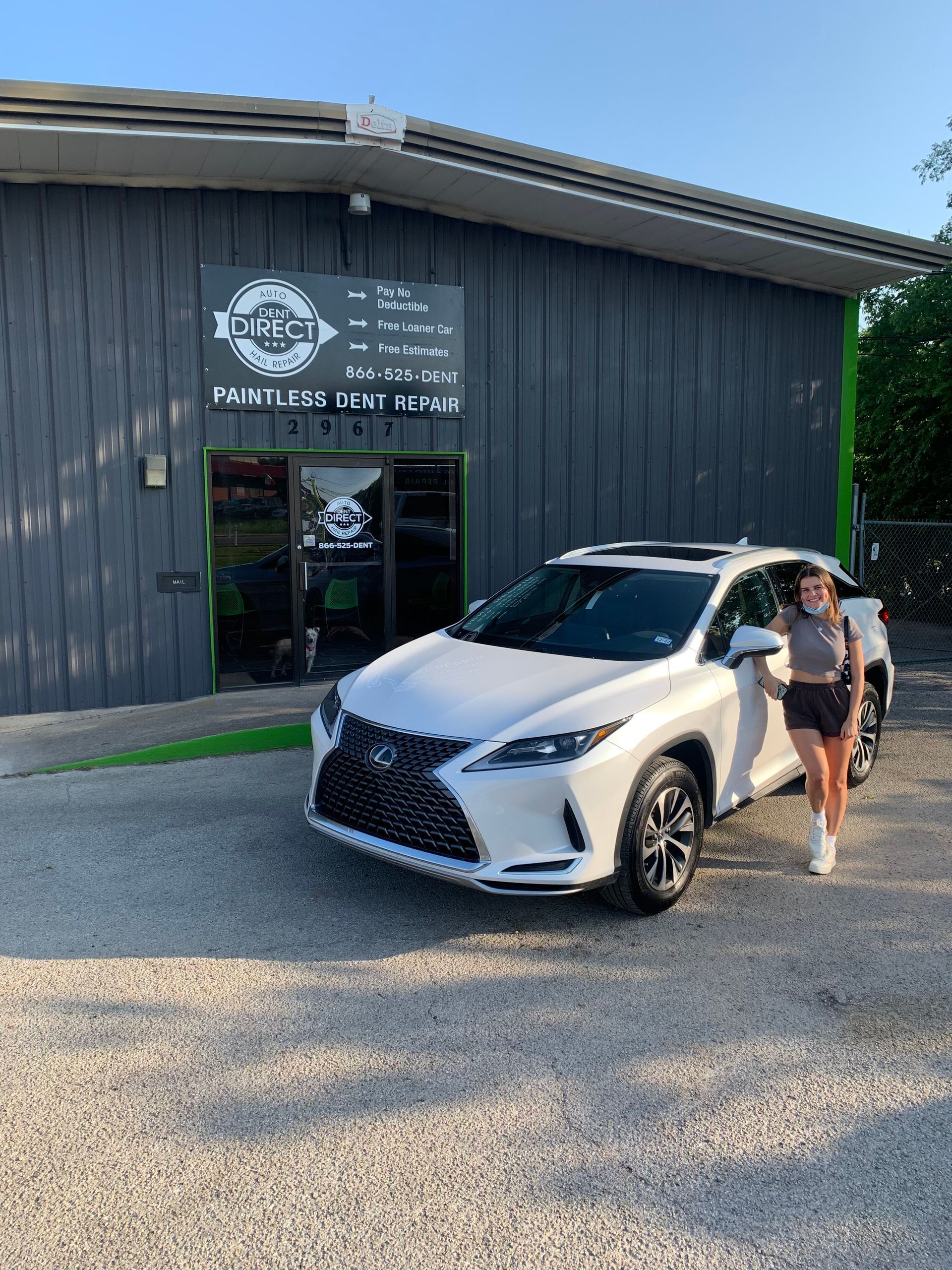 A woman is standing in front of a white lexus rx 350.