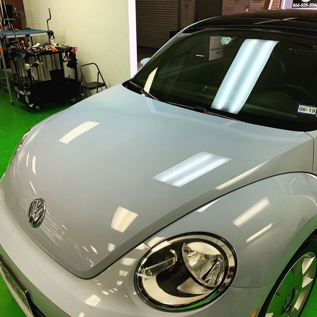 A volkswagen beetle is parked on a green floor