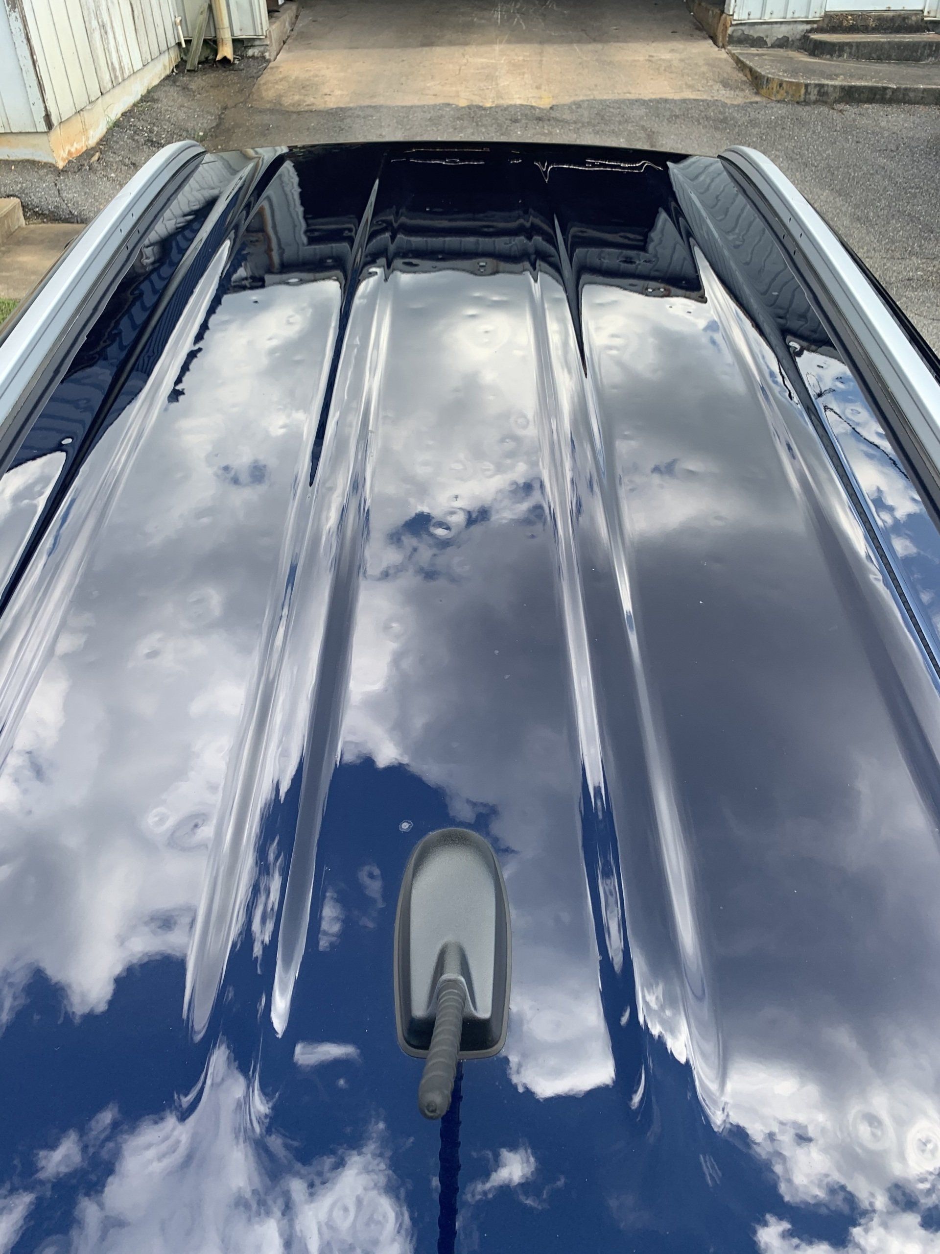 A close up of the roof of a car with a antenna on it.