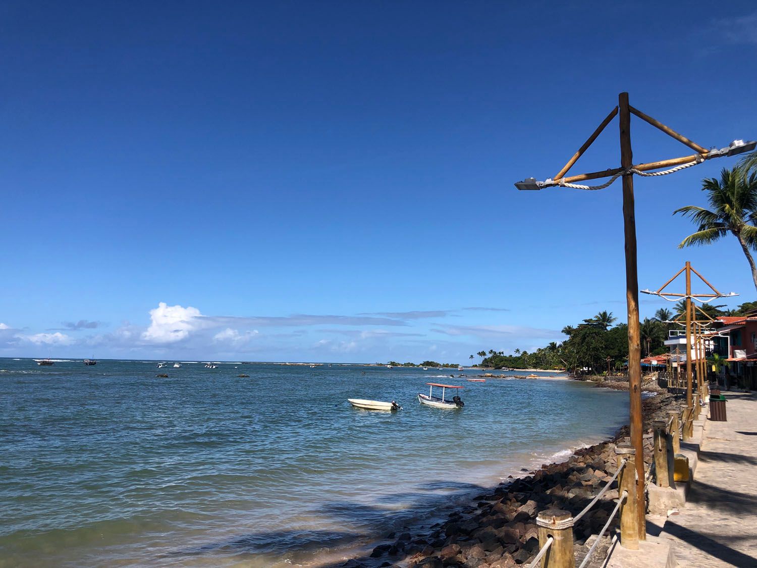 Uma praia com barcos na água e um poste em primeiro plano