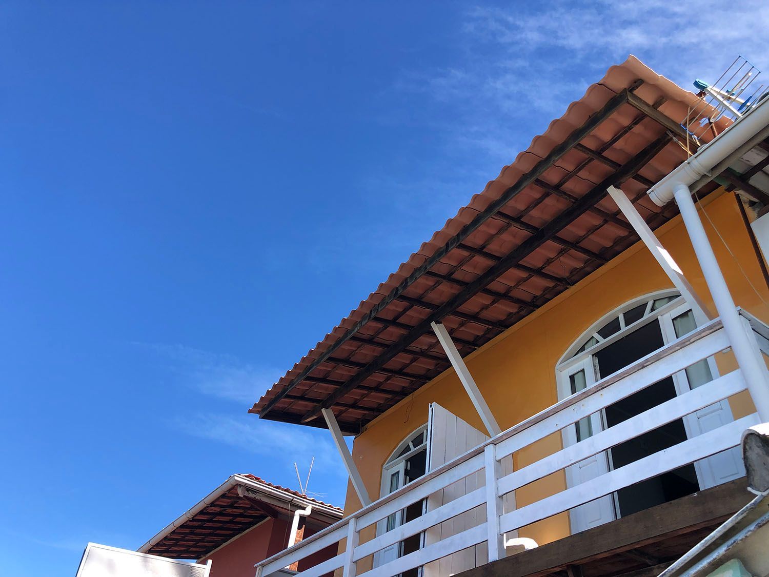 Um prédio com varanda e um céu azul ao fundo